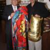 Wilfried Sauerland presents Hall director Ed Brophy with a boxing robe worn by "King" Arthur Abraham 