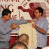 Jim Dundee presents Hall director Ed Brophy with his father, Angelo's, corner man's jacket
