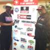 Michael (left) and Leon (right) Spinks pose by the Hall of Fame sponsor banner