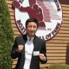 Two-time Olympic gold medalist Zou Shiming in fighting stance by the Hall of Fame logo
