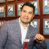 Marco Antonio Barrera proudly posing with his Hall of Fame ring  by his Hall of Fame plaque.