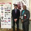 Ring announcer David Diamante and Earnie Shavers pose by the HOF sponsors banner