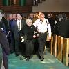 Josie Basilio is escorted out of St. Agatha’s following mass