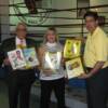 Burchfield, Martin and Hall director Ed Brophy hold some of the Hall's collection of historic programs
