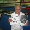 Carlos Ortiz holds programs from the Hall's archives while standing next to the MSG ring he fought in 12 times.