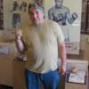 Chuvalo raises a fist in front of photos of ring rivals Joe Frazier and Muhammad Ali.