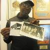 Here Seales holds two photos from the Hall's archives. On the left is the boxing venue in Munich and the photo on the right is Seales with his Olympic teammates.